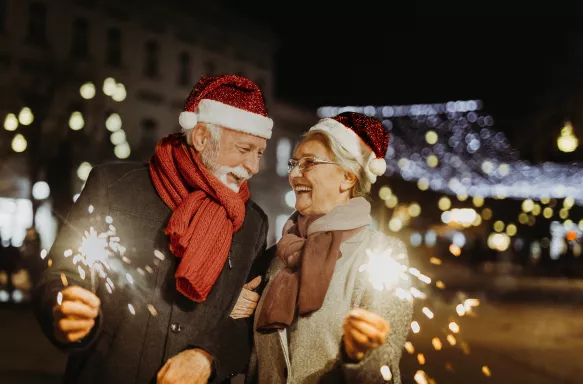 Senior couple in Santa hats shopping during holidays and smiling together