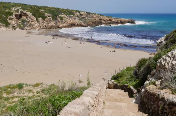 View of Calamosche beach with rocky hills and white sand in Sicily, Italy