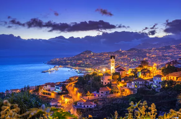 Night view of São Gonçalo parish and the cityscape, harbour and surrounding mountains of Funchal in Madeira, Portugal. 