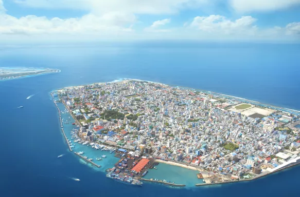 Aerial view of Male, surrounded by bright blue ocean waters in the Maldives.