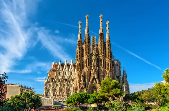 The La Sagrada Familia cathedral in Barcelona against a bright blue sky on a sunny day.