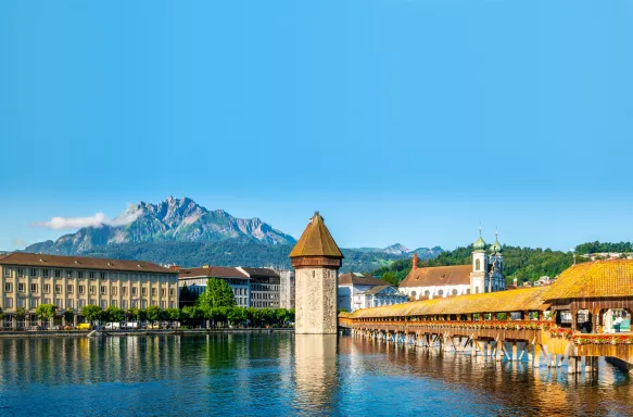 Scenic panoramic view of Lucerne, Switzerland with Chapel bridge or Kapellbrucke and Pilatus mount with clear blue sky during summer