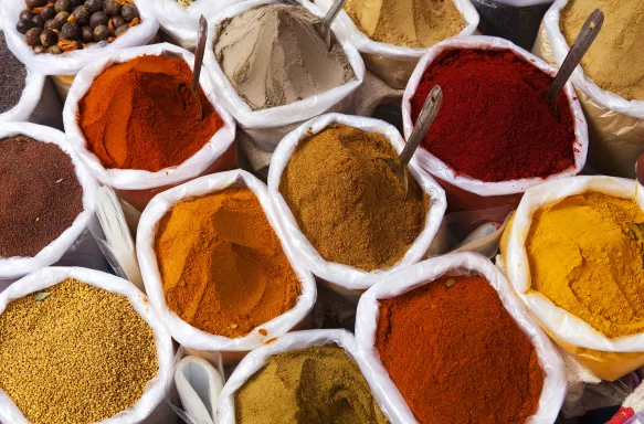 Rows of bags filled with to the brim with powdered spices at Indian market