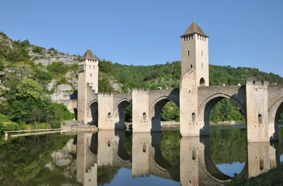 Pont Valentré Bridge reflecting it's image in the Lot River, Cahors, France