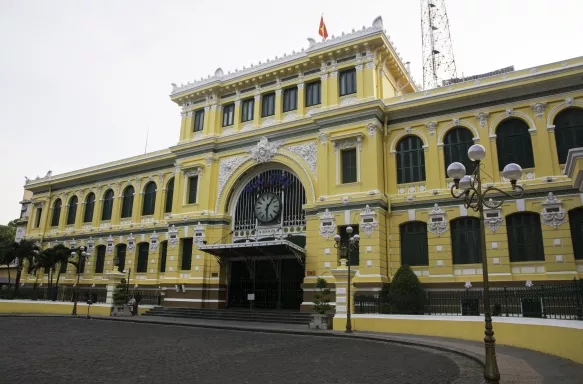 Saigon Central Post Office, large yellow building with white accents, Vietnam.