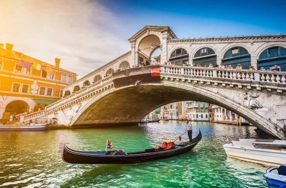 Gondola on Canal Grande with Rialto Bridge at sunset in Venice, Italy