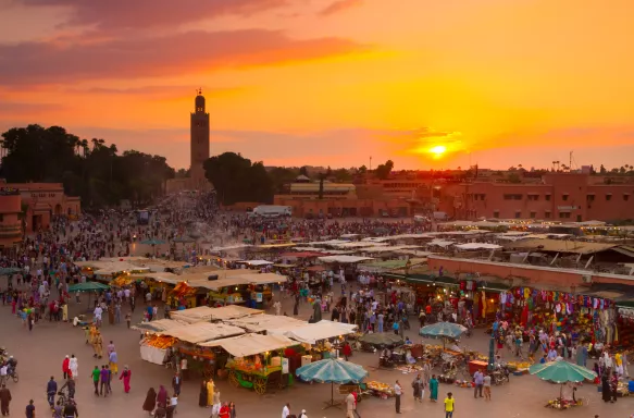 Jamaa el Fna market square at golden hour in Marrakesh, Morocco.