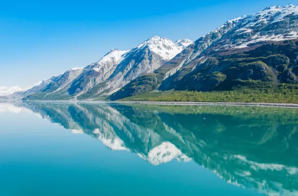 Snowy mountains being reflected on clear waters in Glacier Bay National Park, Alaska