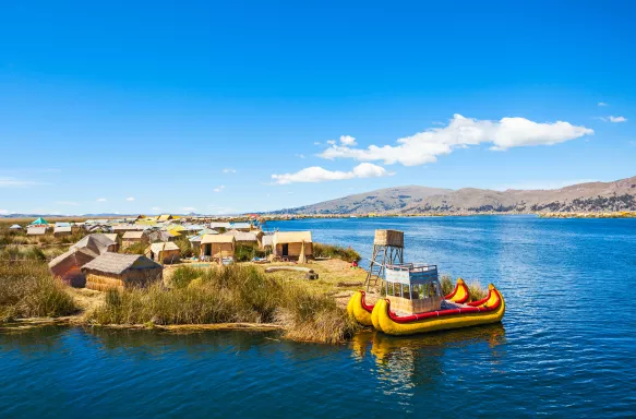 The floating islands on Titicaca Lake, featuring moored kayaks and wooden cabins