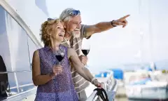 Happy senior couple enjoying wine on yacht