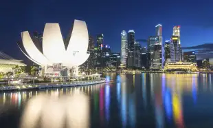 Singapore city skyline with high-rise buildings and lights reflecting on water at night