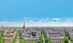 A view of Paris rooftops with the Eifel Tower on the horizon