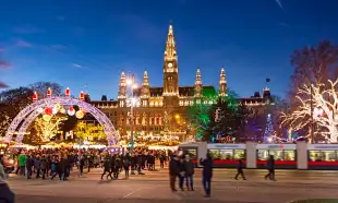 Christmas market with festive lights during the late evening in Rathausplatz square, Vienna, Austria