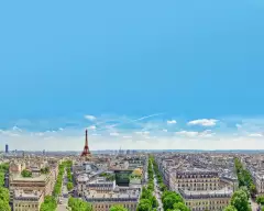 A view of Paris rooftops with the Eifel Tower on the horizon