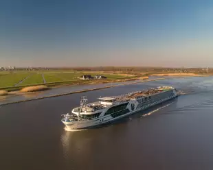 Distant side shot of the George Eliot, on a river