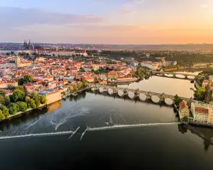 Aerial view of Prague Castle, cathedral and Charles Bridge at sunrise in Prague