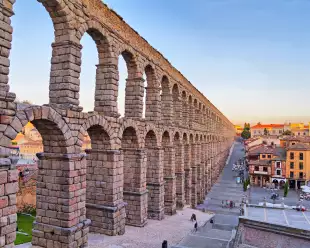 Roman aqueduct of Segovia under a sunset sky