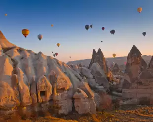 Hot air balloons rising up in the sky, in Cappadocia, Turkey.