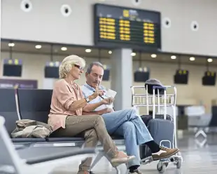 Senior Couple looking at the mobile phone at the airport