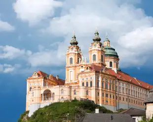 A distant view of Melk abbey on a rocky outcrop above the Danube river, Austria