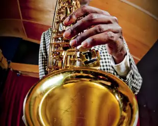 Fish-eye lens view of man playing the saxophone to the camera