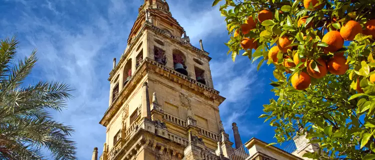 A view of the Bell Tower of Mosque-cathedral of Cordoba beneath a sky blue.