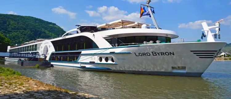 Side view of the MS Lord Byron docked near the coast