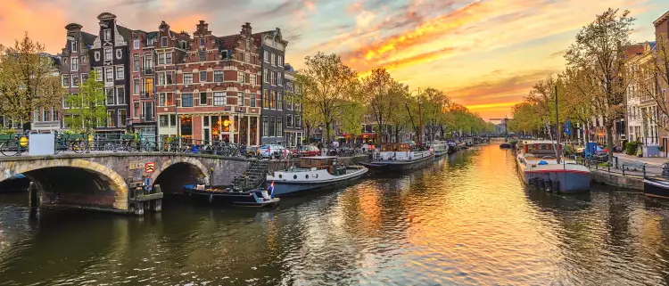 Sunset city skyline at canal waterfront in Amsterdam, Netherlands