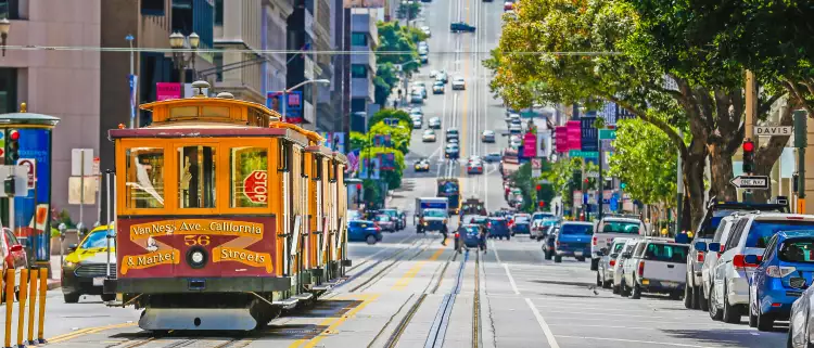 A tram cable car in a busy San Francisco street 