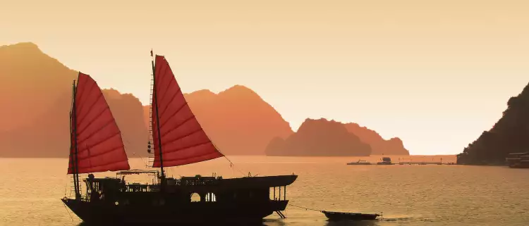 Junk boat at sunset in Halong Bay, Vietnam