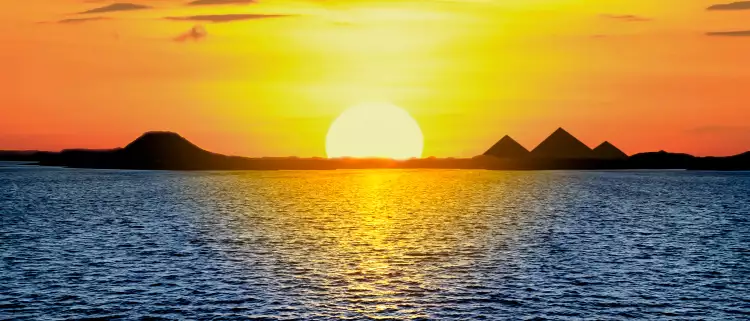 Beautiful sunset light reflecting in the sea and the Egyptian Pyramids
