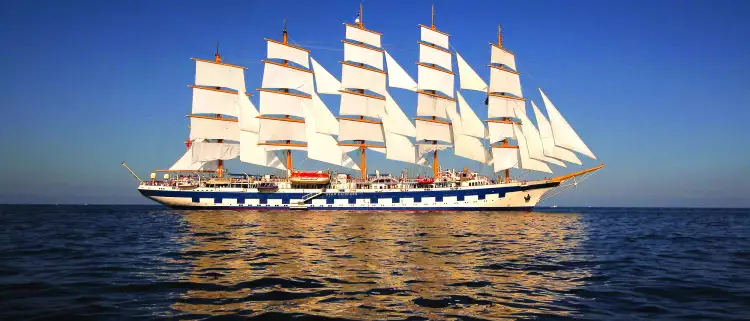 Exterior shot of the Royal Clipper ship at sea against a dark blue sky