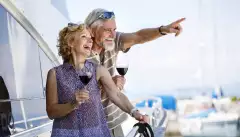 Happy senior couple enjoying wine on yacht