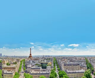 A view of Paris rooftops with the Eifel Tower on the horizon