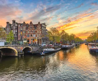 Sunset city skyline at canal waterfront in Amsterdam, Netherlands