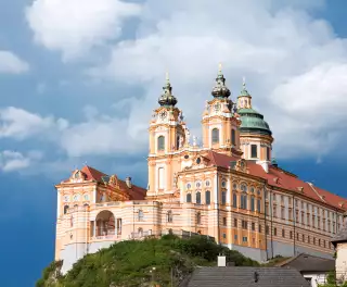 A distant view of Melk abbey on a rocky outcrop above the Danube river, Austria