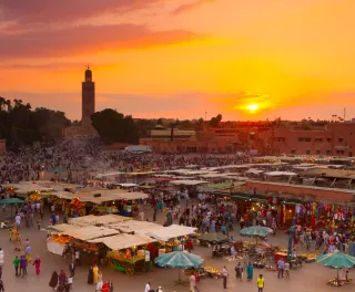 Jamaa el Fna market square at golden hour in Marrakesh, Morocco.